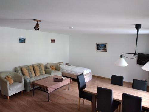 ein Wohnzimmer mit einem Sofa und einem Tisch in der Unterkunft Hotel Garni Post in Grainau
