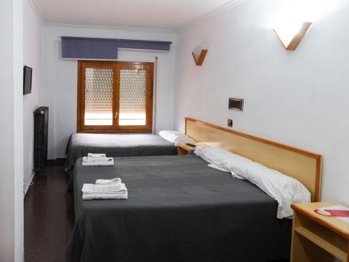 Habitación con 2 camas y toallas. en Hostal Gabás, en Borja
