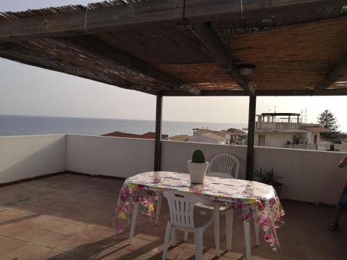 a table and chairs on a balcony with a view of the ocean at A casa di Nanè in Marina di Ragusa