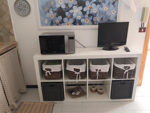 a tv sitting on a shelf with a computer monitor at A casa di Nanè in Marina di Ragusa