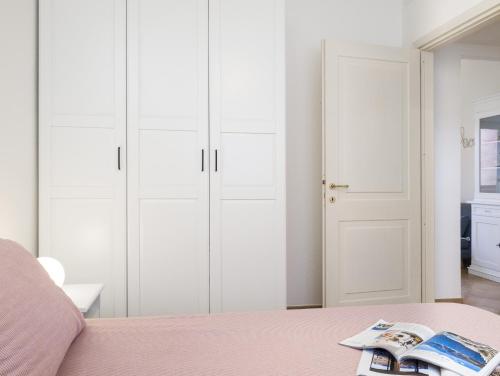 a bedroom with white cabinets and a pink bed at Myrsine 7S - Klodge in Murta Maria