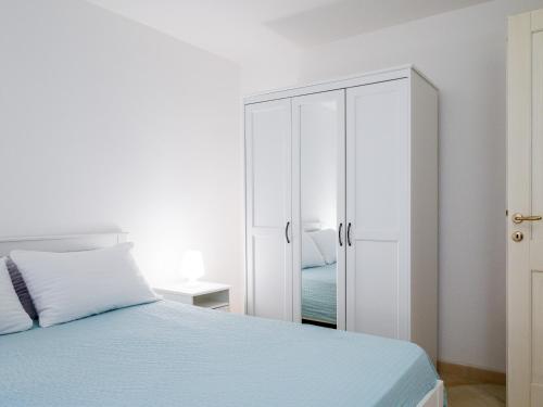a white bedroom with a bed and a closet at Myrsine 7S - Klodge in Murta Maria