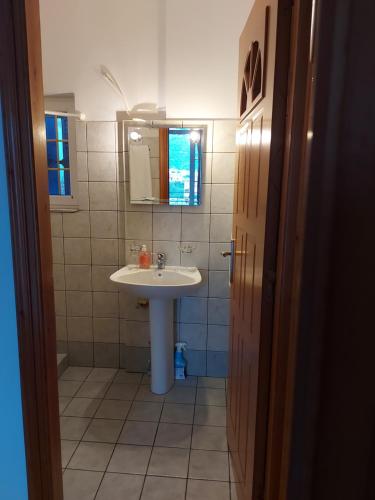 ein Bad mit einem Waschbecken und einem Spiegel in der Unterkunft Matina Apartments Tyros in Tiros