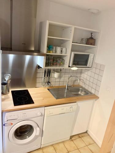 une cuisine avec un évier et une machine à laver dans l'établissement Maison proche Golf & Plages, à Moliets-et-Maa