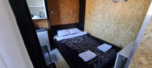a small bed in a small room with white pillows at SUB HEL. Budżetowe pokoje w domu z basenem. Wokół domu tylko natura. Balkon zbyteczny. in Hel