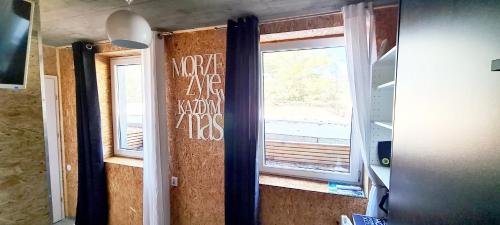 a room with a window with writing on the wall at SUB HEL. Budżetowe pokoje w domu z basenem. Wokół domu tylko natura. Balkon zbyteczny. in Hel