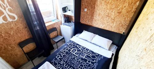 a small bedroom with a bed in a trailer at SUB HEL. Budżetowe pokoje w domu z basenem. Wokół domu tylko natura. Balkon zbyteczny. in Hel