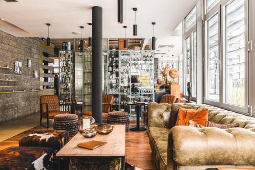 a living room with couches and a table at Cosmopolite Hotel Nieuwpoort-Bad in Nieuwpoort