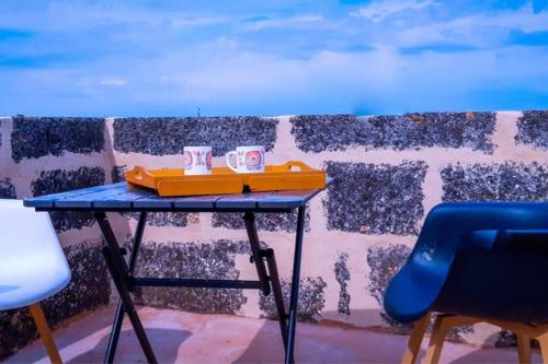 une table avec deux tasses à côté d'un mur dans l'établissement INSOLITE STUDIO -La Tour des Templiers-, à Montfrin