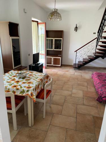a living room with a table and a staircase at Villa del Sole in Terracina