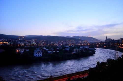 a view of a river with a city at night at Hotel RichI G A in Tbilisi City