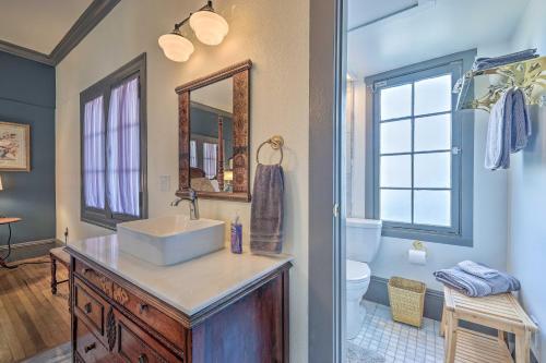 ein Badezimmer mit einem Waschbecken, einem WC und einem Spiegel in der Unterkunft Elegant, Historical Santa Ana Home with Gardens in Santa Ana