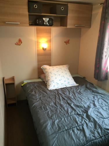 a small bedroom with a bed with a pillow at ALINOA in Ouistreham