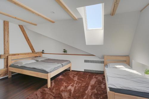 a attic room with two beds and a window at Loft Apartmán Šumava in Sušice