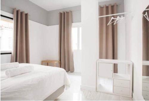 Un dormitorio blanco con una cama blanca y una ventana en Dion Suites en Athens