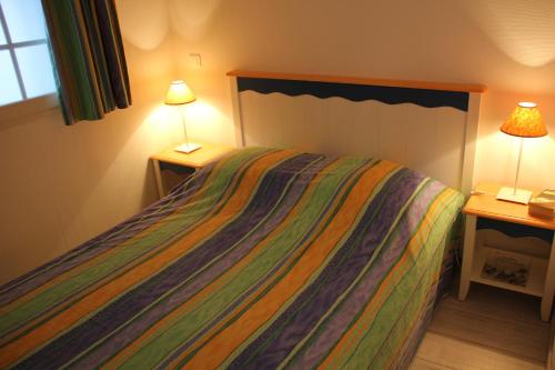 sypialnia z łóżkiem z narzutą i 2 lampami w obiekcie BELLE DUNE la place apt 212 w mieście Fort-Mahon-Plage