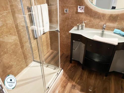 La salle de bains est pourvue d'une douche et d'un lavabo. dans l'établissement Apartamento da Seara "Lamego", à Lamego