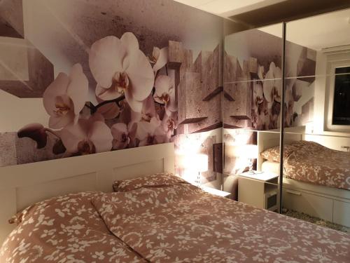 um quarto com uma cama e um mural de flores na parede em Apartman 33 FREE PRIVATE GARAGE em Novi Sad