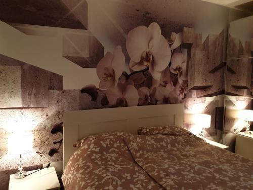 1 dormitorio con 1 cama con flores en la pared en Apartman 33 FREE PRIVATE GARAGE en Novi Sad