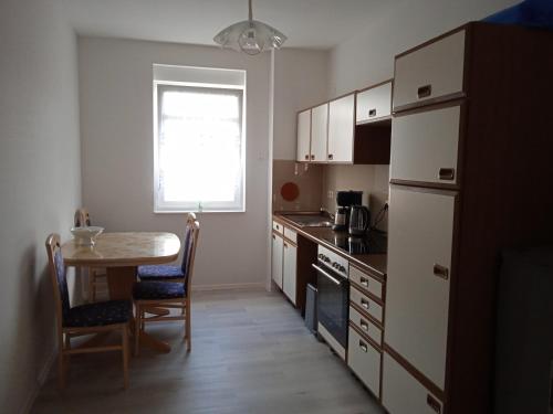 a kitchen with a table and a small table and a table and chairs at Gästewohnung OC in Oschersleben