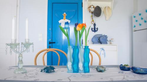 a table with a blue vase with flowers in it at Blue Paradise maisonette in Paliouri