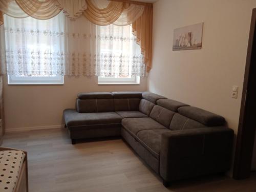 a living room with a couch and two windows at Gästewohnung OC in Oschersleben
