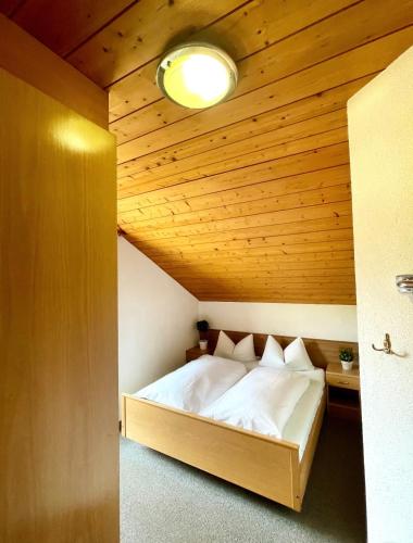 a bed in a room with a wooden ceiling at Apartments Spirit of Mountains in Rasun di Sopra