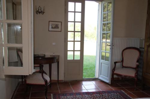a room with two chairs and a table and doors at Le Mas des Pins in Mane
