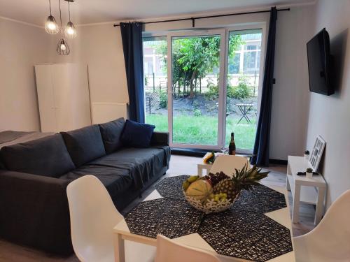 een woonkamer met een bank en een tafel bij River House - Apartament z ogródkiem in Szczecin