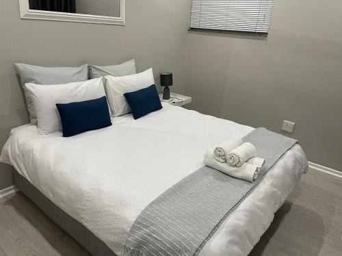 um quarto com uma grande cama branca com almofadas azuis em 901 Umdloti Beach Resort em Umdloti