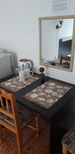 a table with a mirror and a table with a chair at Къща за гости Янка in Nesebar