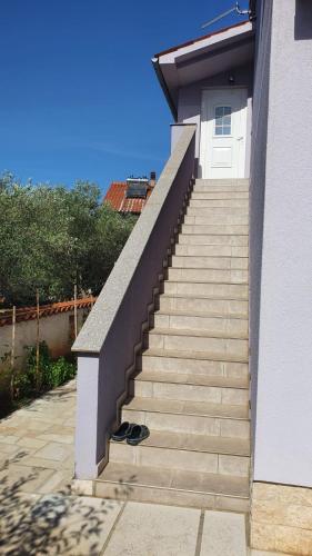 a set of stairs leading to a white door at Apartman Lavanda in Peroj