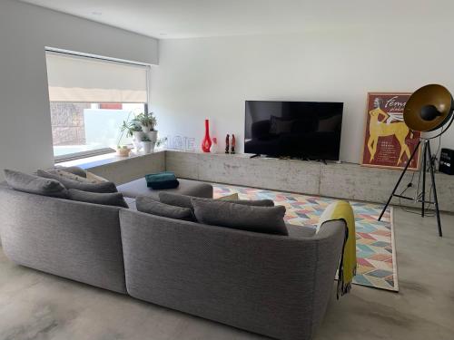 a living room with a couch and a flat screen tv at A Casa do Abílio em Alvarenga in Alvarenga