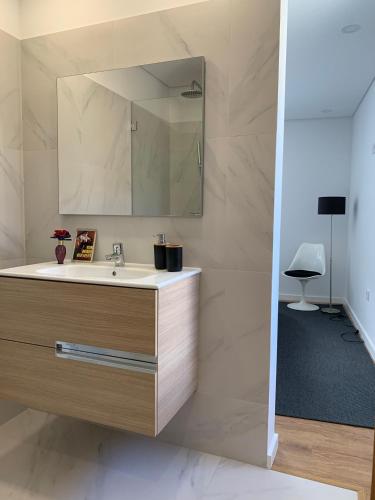 a bathroom with a sink and a mirror at A Casa do Abílio em Alvarenga in Alvarenga