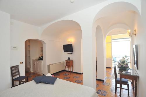 a bedroom with a bed and a desk and a television at Hotel Belvedere in Conca dei Marini