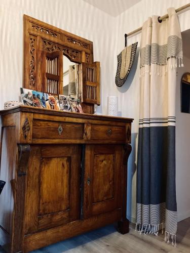 - une commode en bois avec un miroir au-dessus dans l'établissement La Maison des Marais de Sallertaine, à Sallertaine