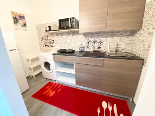 a kitchen with a red rug on the floor at 35 Passi dal mare B&B in Cirò Marina