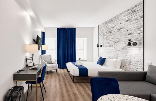 a hotel room with a king sized bed and a desk at Les Lofts du Théâtre in Quebec City