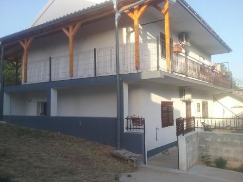 Cette maison blanche dispose d'un balcon avec une terrasse couverte. dans l'établissement MILDA+M, à Skradin