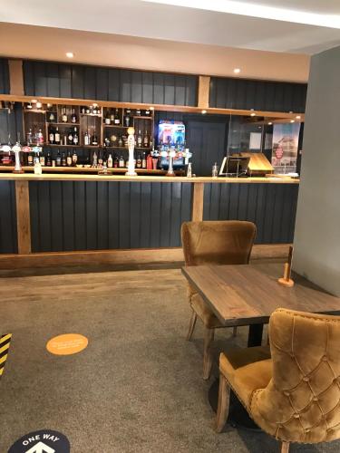 a bar with chairs and a wooden table and a counter at Bude 13 in Cubert