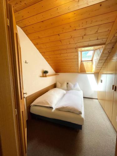 a bed in a room with a wooden ceiling at Apartments Spirit of Mountains in Rasun di Sopra