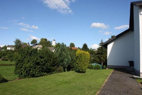 a yard with a house and some bushes and trees at Ferienhaus-Naturblick in Berndorf