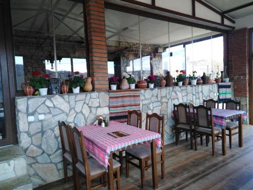 a restaurant with tables and chairs and a stone wall at Sermeninski Cardak in Sermenin
