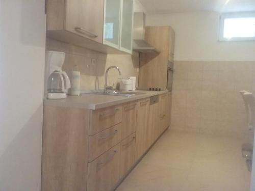a kitchen with wooden cabinets and a sink at MILDA+M in Skradin