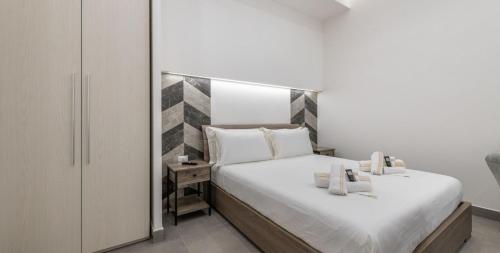 a bedroom with a large bed with white sheets at Ichnusa Rooms in Cagliari