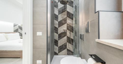 a bathroom with a shower with a sink and a bed at Ichnusa Rooms in Cagliari