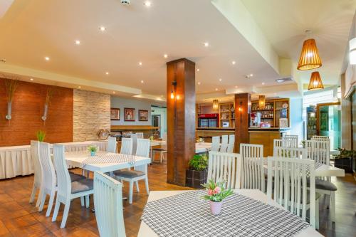 a restaurant with white chairs and a table and a table and chairsktop at Hotel Julia in Sveti Vlas