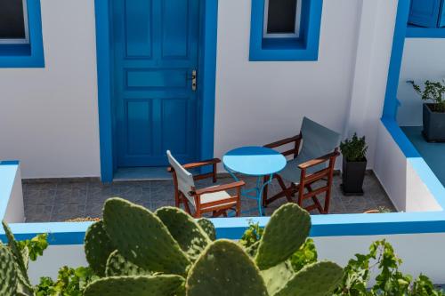 a blue door and chairs and a table and cactus at Ancient Thera Apartments in Kamari