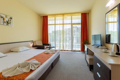 a hotel room with a large bed and a desk at Hotel Julia in Sveti Vlas