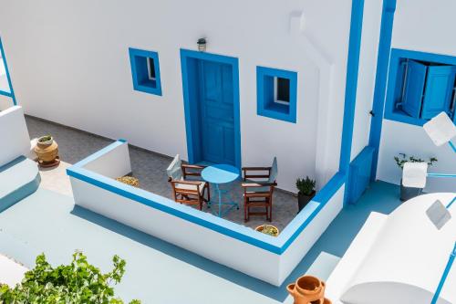 a blue and white house with a table and chairs at Ancient Thera Apartments in Kamari
